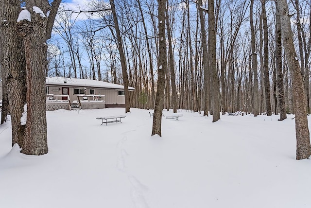 yard layered in snow with a wooden deck