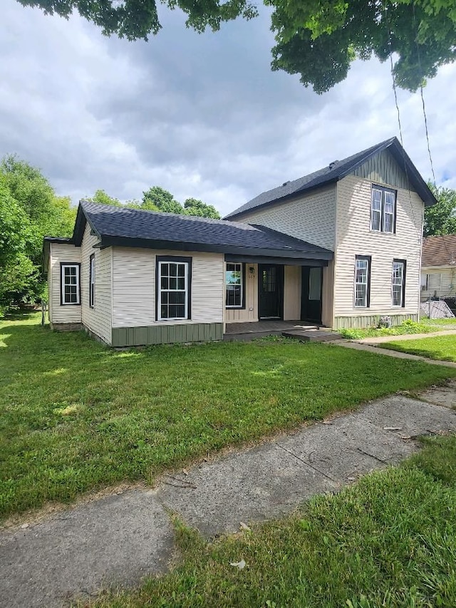 view of front of house featuring a front lawn and roof with shingles