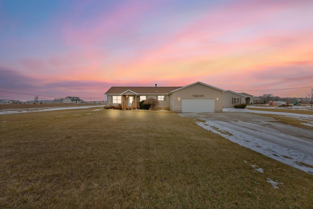 ranch-style home with concrete driveway, a front lawn, and an attached garage