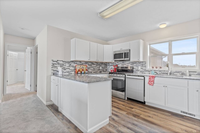 kitchen with stainless steel appliances, visible vents, light stone counters, and white cabinetry