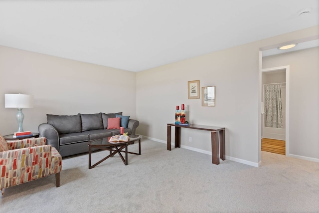 carpeted living area featuring baseboards