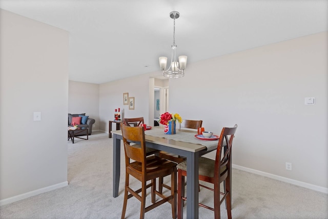 dining space featuring a chandelier, carpet floors, and baseboards