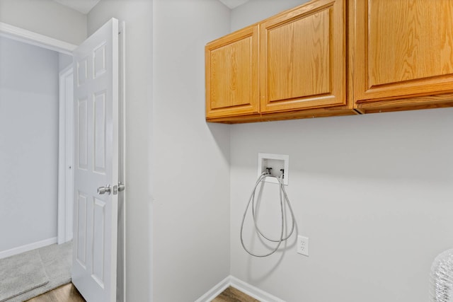 laundry room with cabinet space, baseboards, and washer hookup