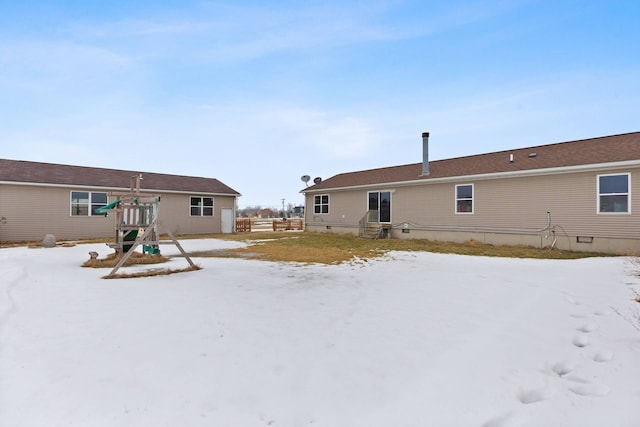 snow covered property featuring crawl space and a playground