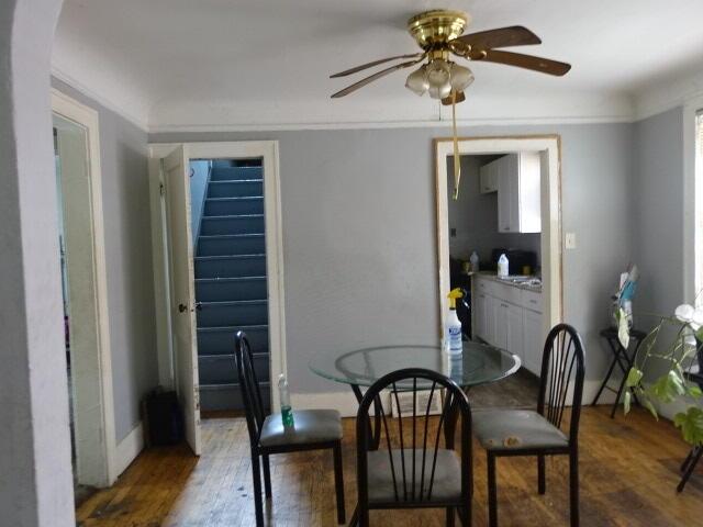 dining area featuring dark wood finished floors, a ceiling fan, and baseboards