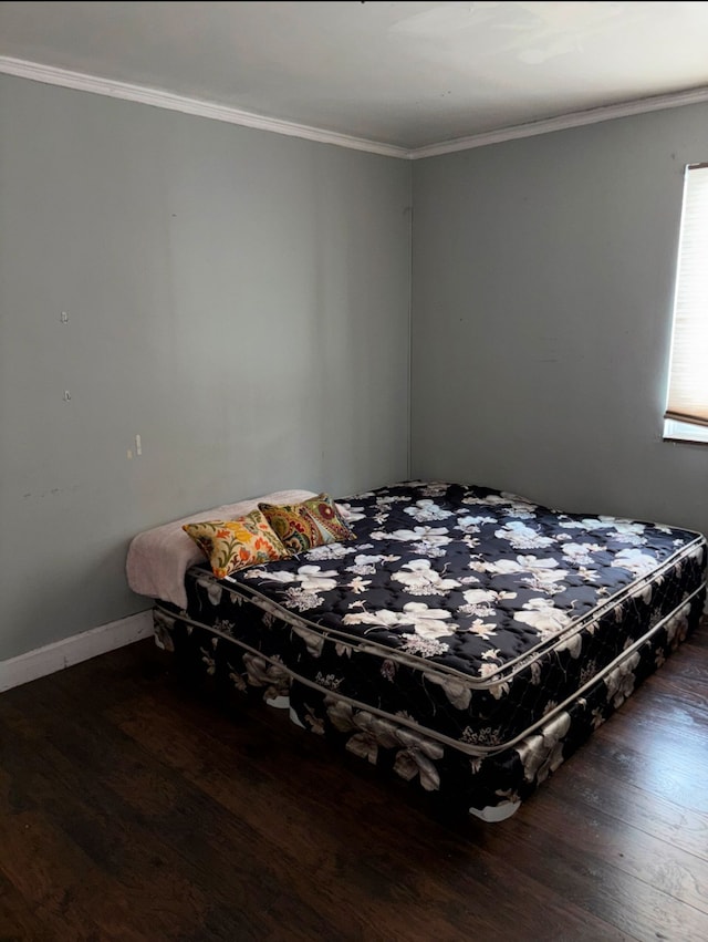 bedroom featuring baseboards, ornamental molding, and wood finished floors