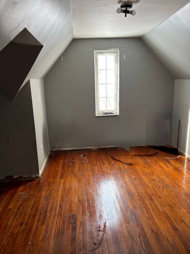 additional living space featuring vaulted ceiling and hardwood / wood-style flooring