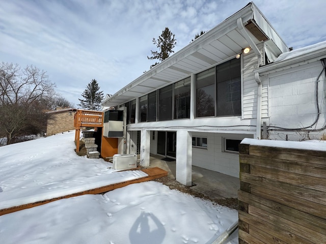 view of snow covered exterior featuring a sunroom