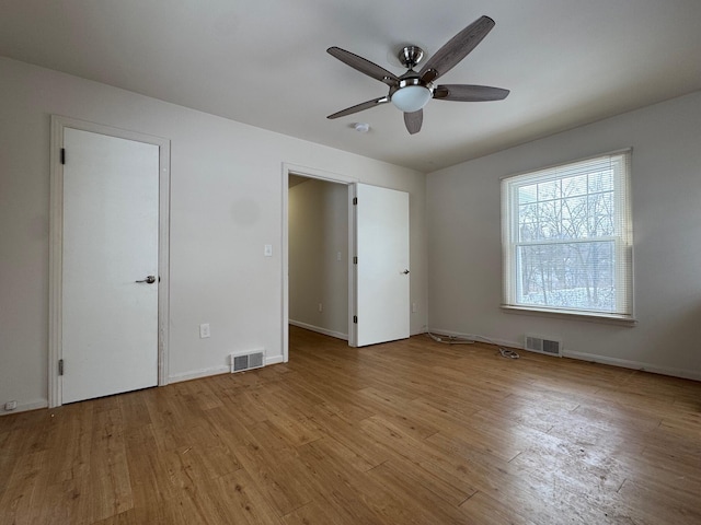 unfurnished bedroom featuring light wood-style floors, baseboards, visible vents, and a ceiling fan