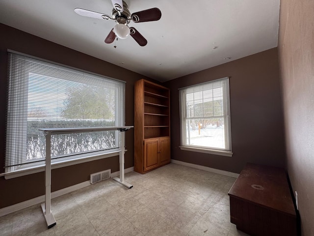 home office with visible vents, ceiling fan, and baseboards