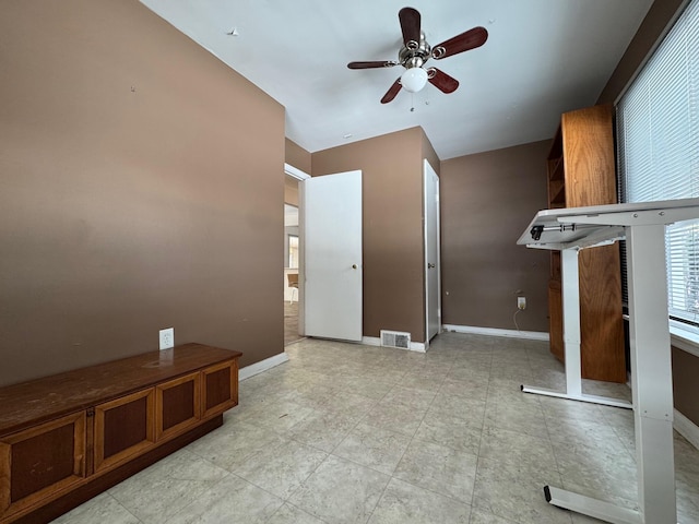 interior space with visible vents, ceiling fan, and baseboards