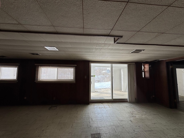 spare room featuring light floors and a paneled ceiling