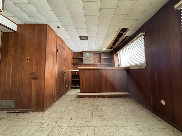 bar with visible vents, wooden walls, and light floors