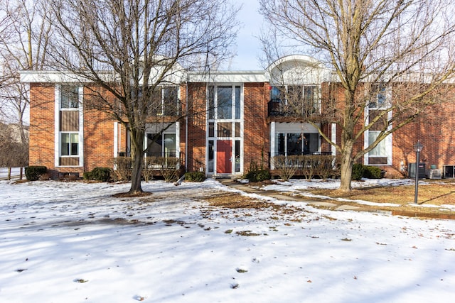 townhome / multi-family property with central AC unit and brick siding