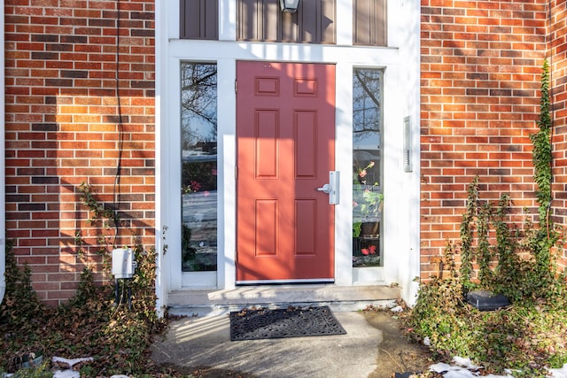 doorway to property with brick siding