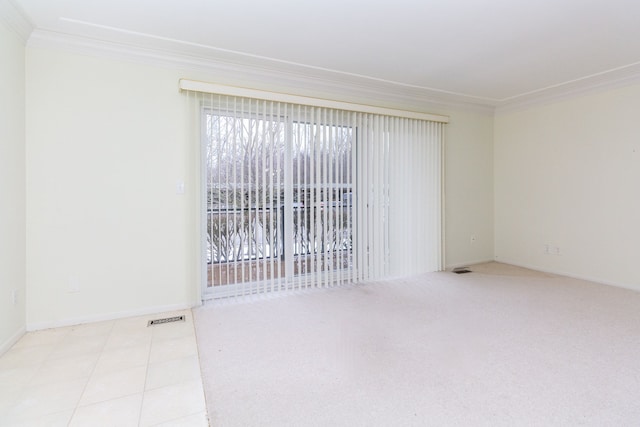 spare room featuring light tile patterned floors, visible vents, ornamental molding, and baseboards