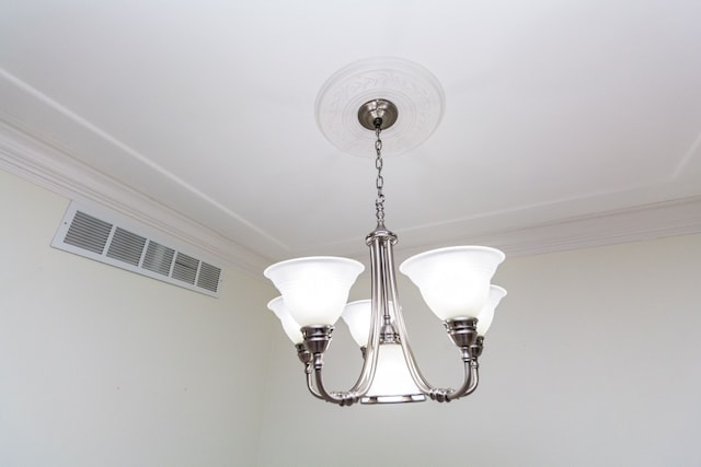 room details with a chandelier, visible vents, and crown molding