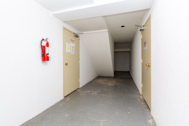 corridor featuring unfinished concrete flooring