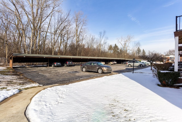 snow covered parking featuring covered and uncovered parking