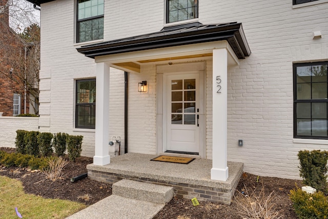 property entrance featuring brick siding