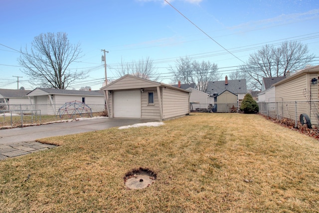 view of yard featuring an outdoor structure, driveway, a detached garage, and fence