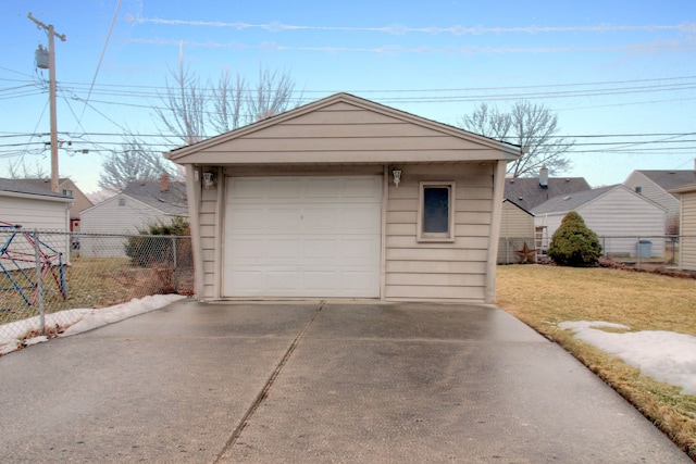 detached garage with concrete driveway and fence