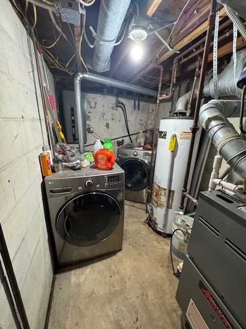 unfinished basement with electric panel, gas water heater, and independent washer and dryer