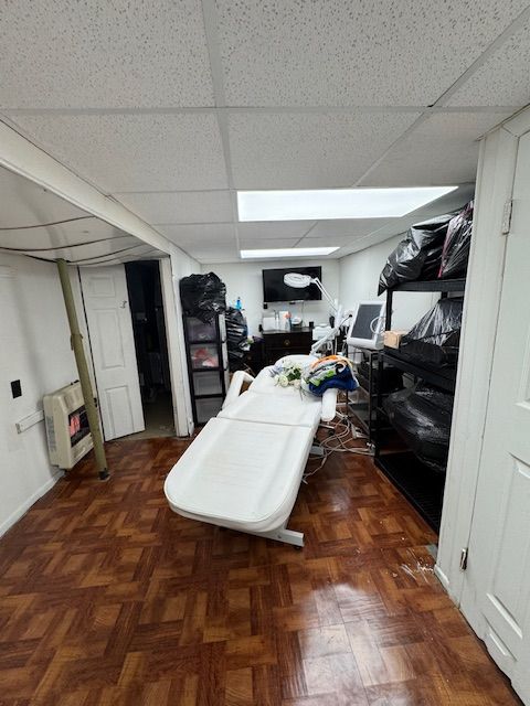 interior space featuring a paneled ceiling and heating unit