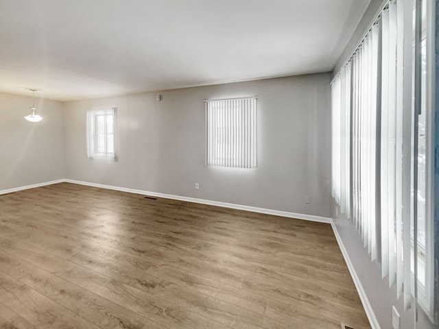 unfurnished room with baseboards and wood finished floors