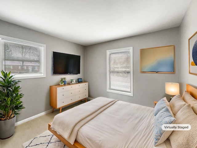 carpeted bedroom with multiple windows and baseboards