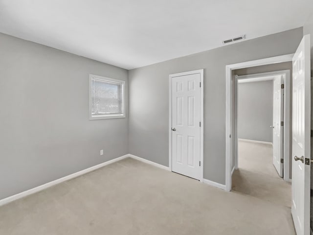 unfurnished bedroom featuring carpet flooring, visible vents, and baseboards