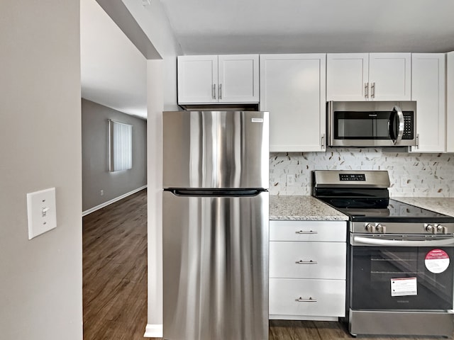 kitchen featuring light stone counters, appliances with stainless steel finishes, dark wood finished floors, and white cabinetry