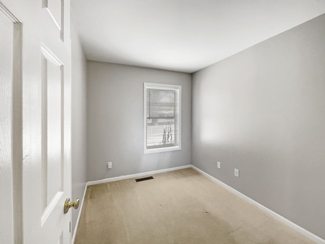 carpeted spare room with baseboards and visible vents