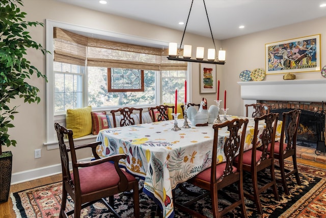 dining room featuring recessed lighting, a fireplace, wood finished floors, and baseboards