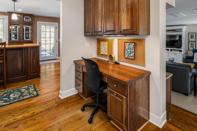 office space with wood finished floors, visible vents, and baseboards