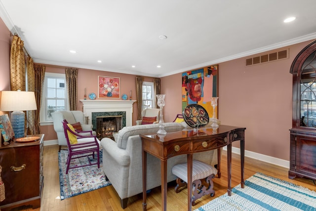 living room with baseboards, a premium fireplace, visible vents, and ornamental molding