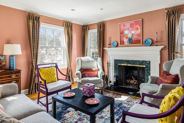 sitting room with baseboards, wood finished floors, a high end fireplace, and crown molding