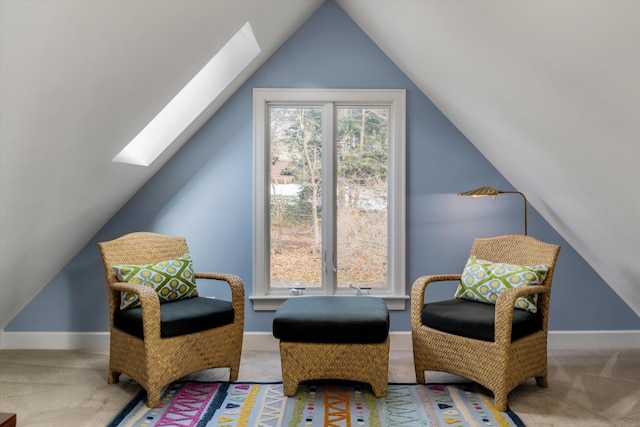 living area with vaulted ceiling with skylight, carpet flooring, and baseboards