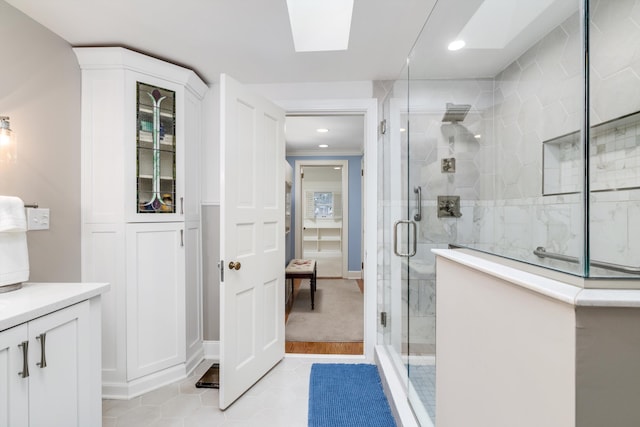 full bath with a stall shower, tile patterned flooring, and a skylight