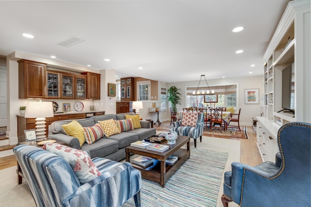 living area with baseboards, light wood-type flooring, visible vents, and recessed lighting