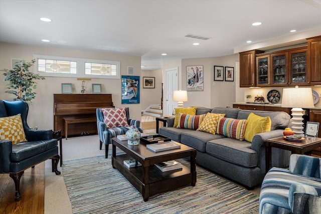 living area with light carpet, stairway, visible vents, and recessed lighting