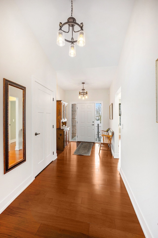 entrance foyer featuring an inviting chandelier, baseboards, and wood finished floors