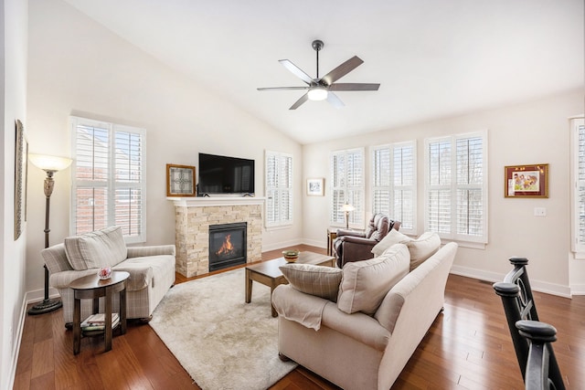 living room with baseboards, dark wood finished floors, ceiling fan, vaulted ceiling, and a fireplace