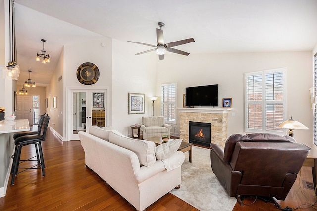 living area with ceiling fan, dark wood-style flooring, a fireplace, and baseboards