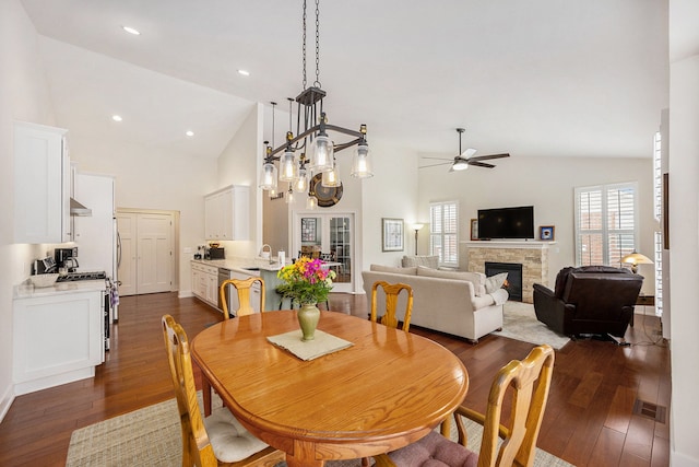 12341 Twin Brook Dr, Romeo, MI 48065 - dining area with a wealth of natural light, a ceiling fan, a stone fireplace, dark wood-style floors, and visible vents