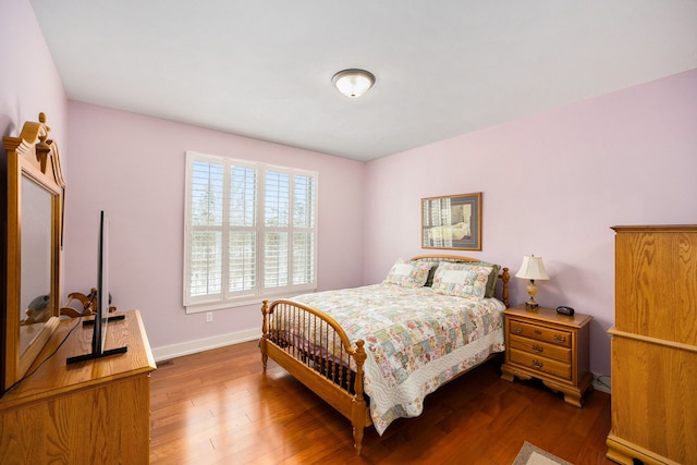 bedroom with dark wood-style floors and baseboards