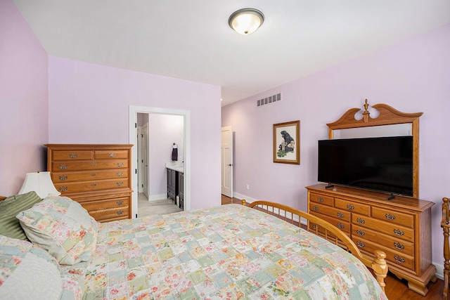 12341 Twin Brook Dr, Romeo, MI 48065 - bedroom featuring ensuite bathroom, baseboards, and visible vents