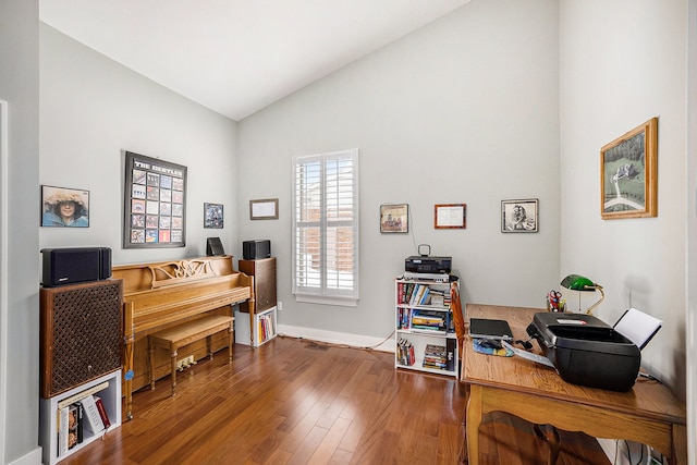 home office with vaulted ceiling, hardwood / wood-style floors, and baseboards