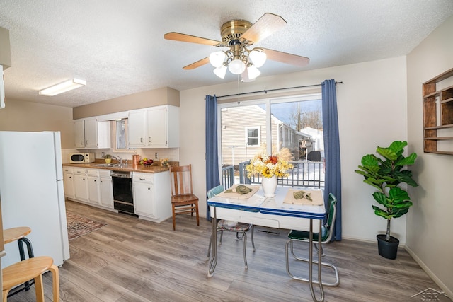 interior space featuring light wood-style floors, ceiling fan, a textured ceiling, and baseboards