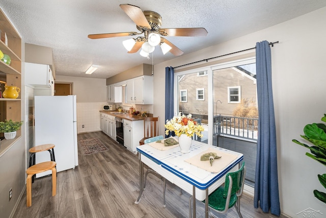 kitchen with light wood finished floors, white cabinets, dishwasher, and freestanding refrigerator